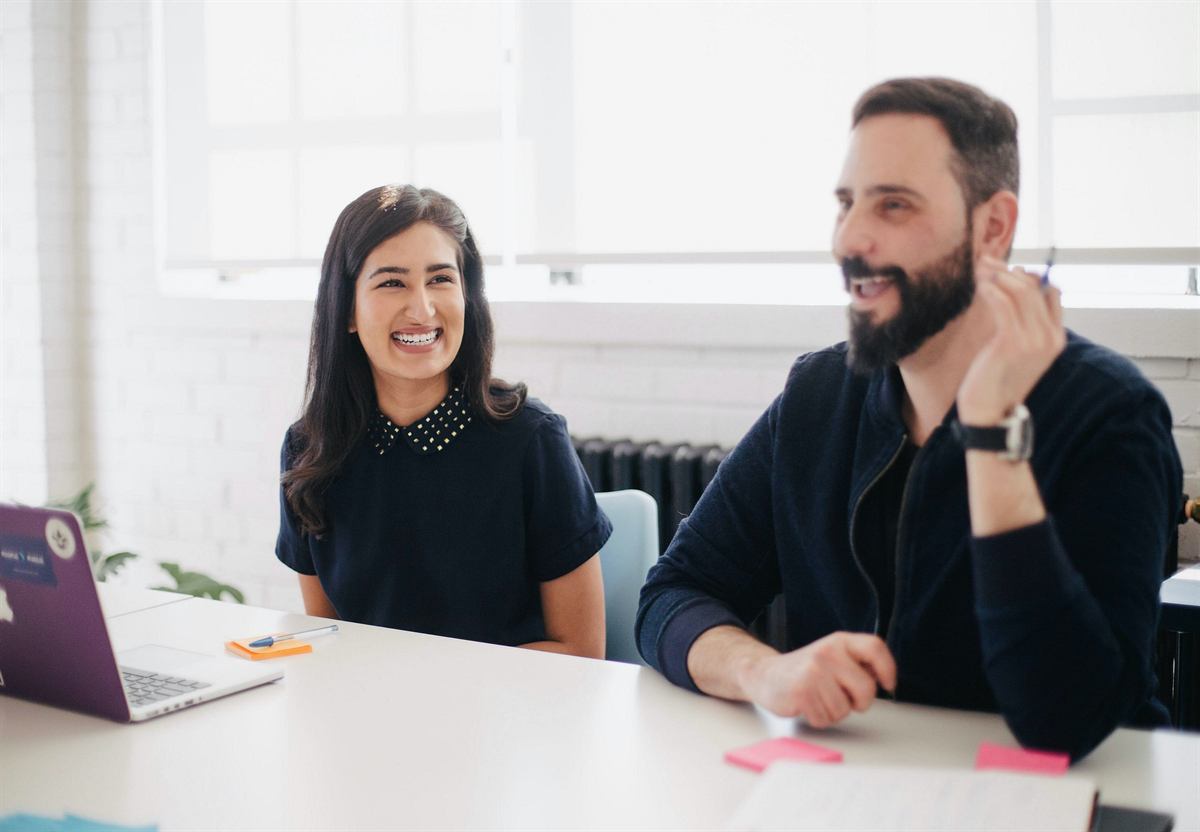 Two colleagues smiling during a consultation
